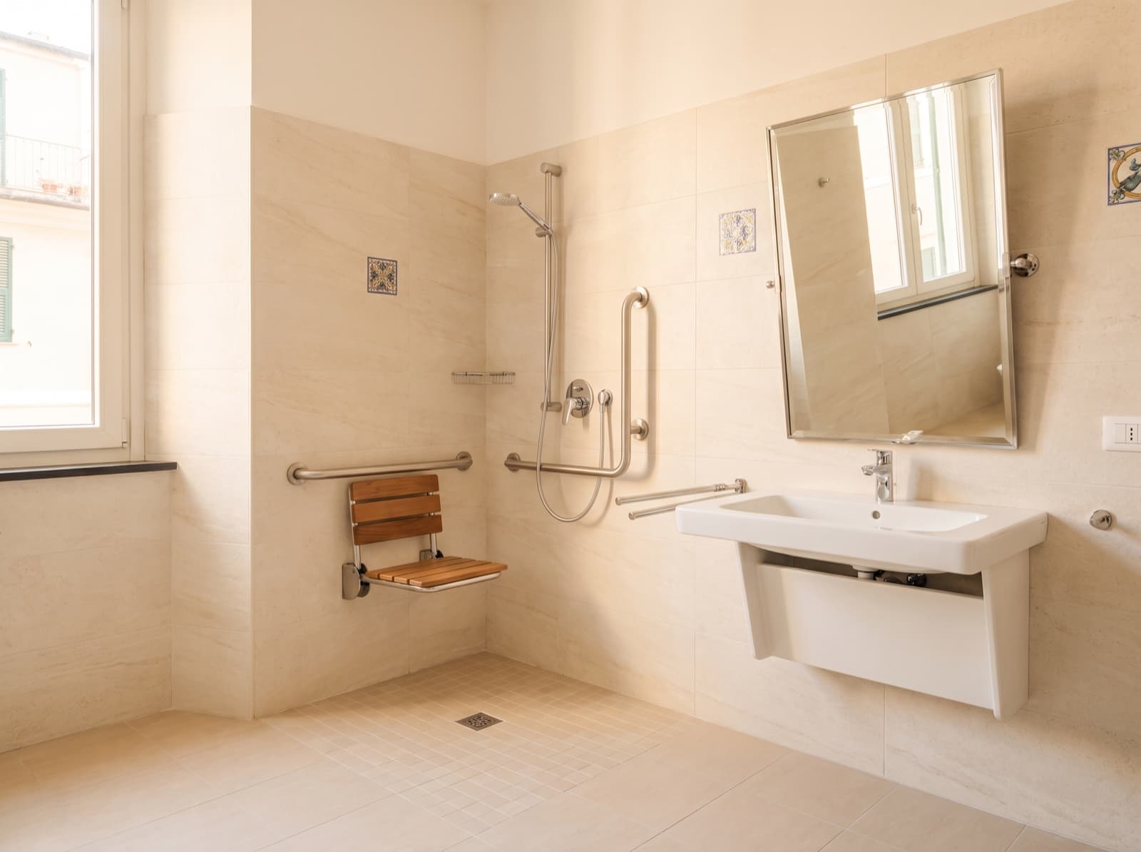 Bagno accessibile con doccia a filo pavimento, seggiolino ribaltabile e maniglioni