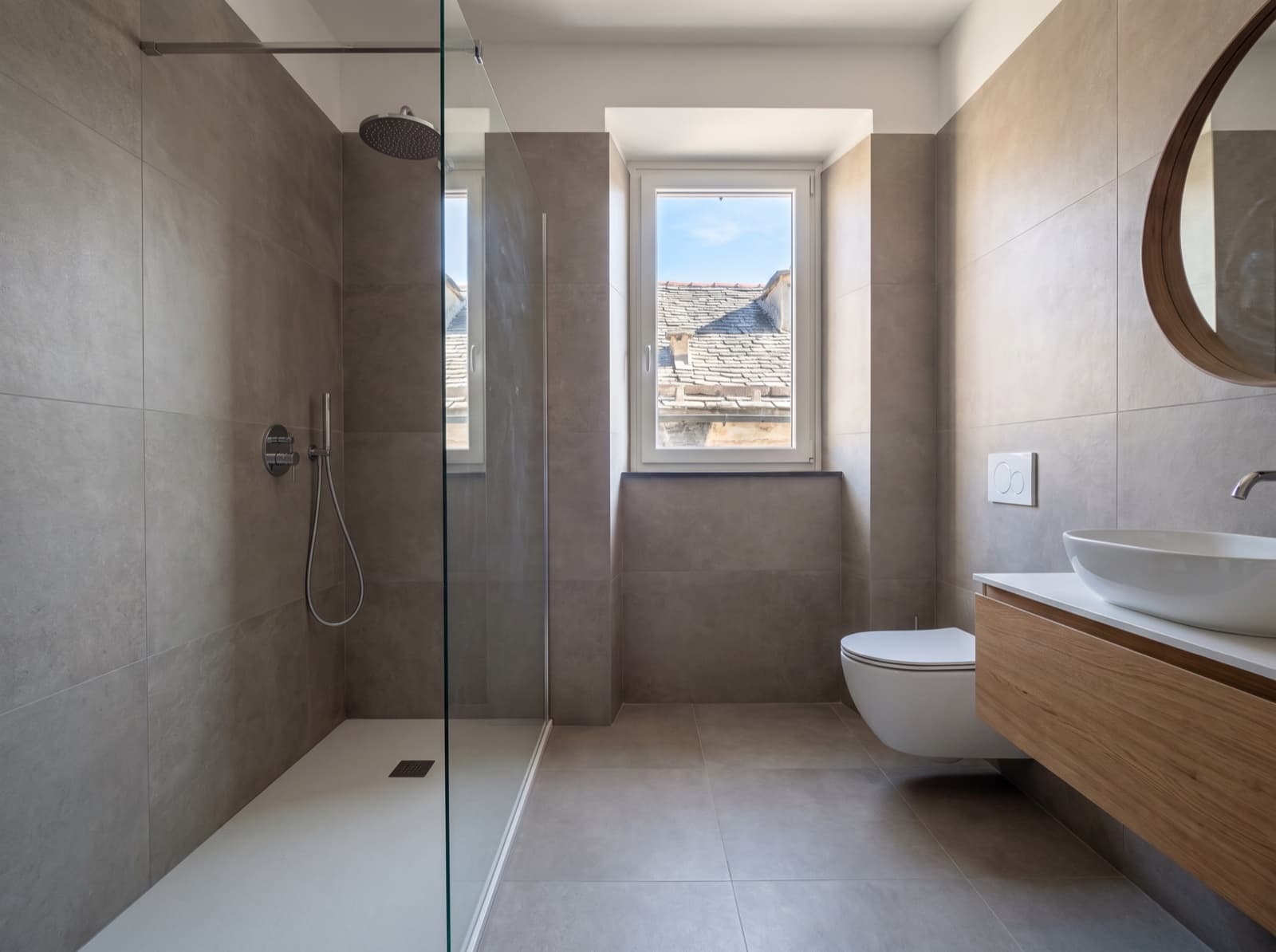 Bagno ristrutturato con doccia a filo pavimento e mobile sospeso in legno